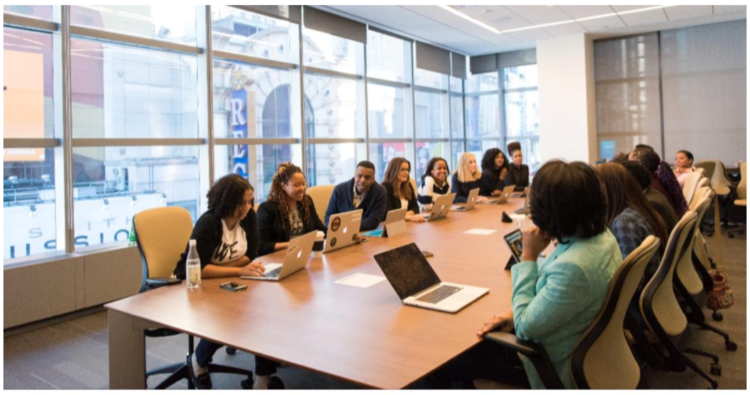 Big team sat around a conference room table