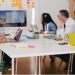 Team sitting around a table looking at a shared screen in a meeting