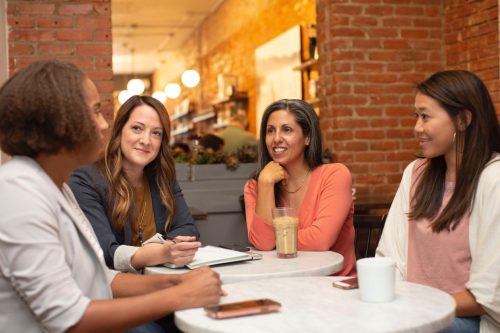Four women speaking around a table