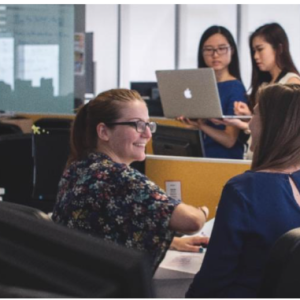 Office work place with people talking in the foreground and background